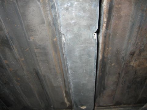 1976 Ford Ranchero - Close-up of the undercarriage, showing ribbed metal panels and a central support structure.