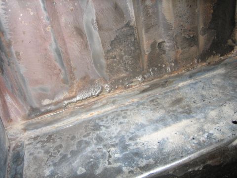 1976 Ford Ranchero - Close-up of the underside of a vehicle frame, revealing rust and metal fatigue.
