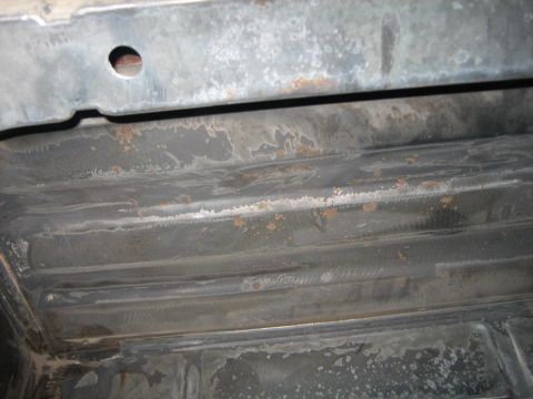 1976 Ford Ranchero - The underside of a vehicle shows extensive rust and corrosion on its metal components.