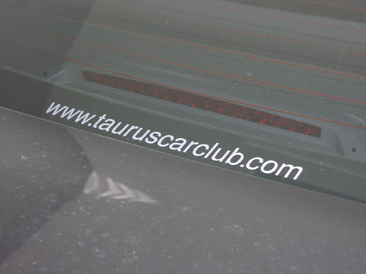 White www.tauruscarclub.com decal on dark rear window above third brake light