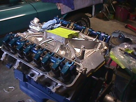 1963 Ford Fairlane - Close-up of an engine block assembly, showing blue rocker arms and an intake manifold.