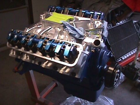 1963 Ford Fairlane - V8 engine assembly with blue valve covers and intake manifold, placed on an engine stand.
