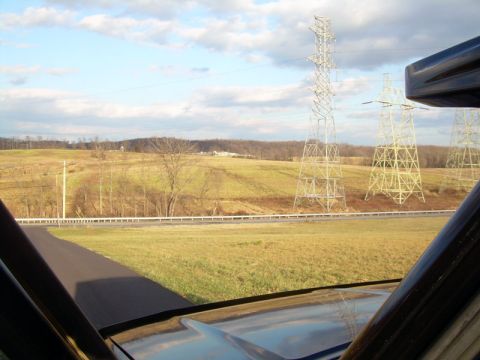 1992 Ford Bronco - View from inside a vehicle looking out at a rural landscape with power lines under a cloudy sky.