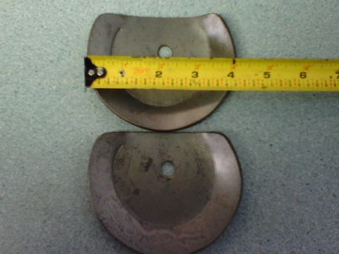 1984 Ford Bronco - Two metal parts are shown with a tape measure for scale. The tape measure indicates measurements in inches.