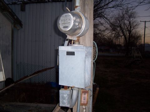 2004 Aston Martin Virage - An outdoor electrical meter and junction box are mounted on a wooden pole.