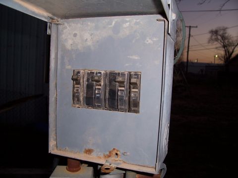 2004 Aston Martin Virage - An outdoor electrical breaker box with four switches is visible against a dusky sky.