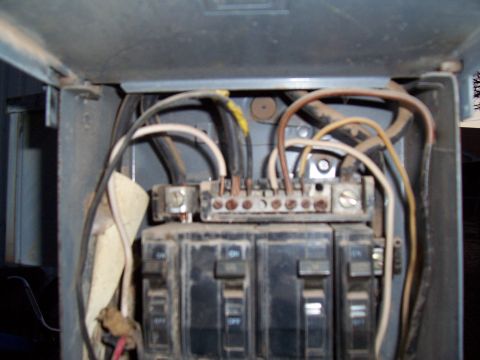 2004 Aston Martin Virage - Interior view of an electrical panel showing circuit breakers and wiring connections.