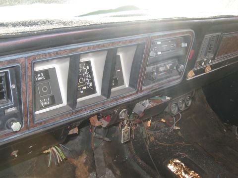 1974 Ford F-100 - The interior of a 1973 Ford F-Series truck reveals a dashboard with faux woodgrain accents and visible wiring beneath the dash.