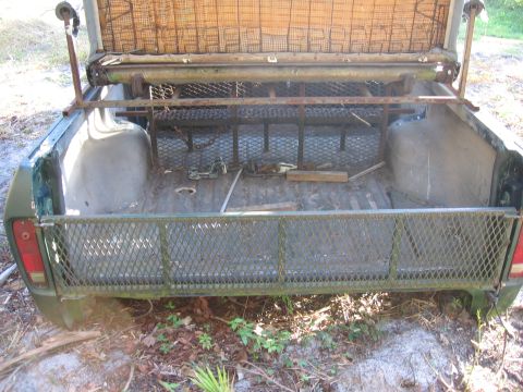 1974 Ford F-100 - The bed of a 1973 Ford F-100 pickup truck, equipped with a metal rack and mesh tailgate.