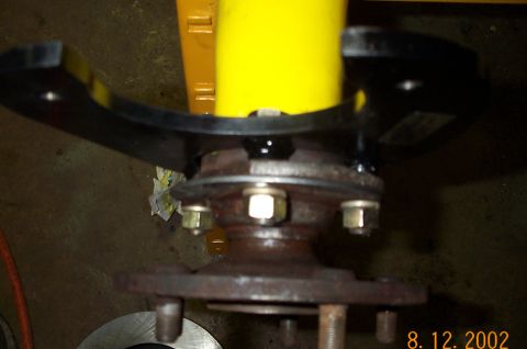 1986 Ford Bronco - Close-up of a vehicle's rear axle component, showing rust and a black bracket.
