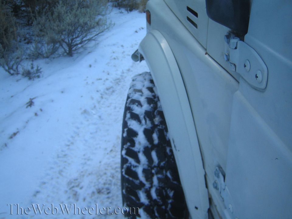 1987 Suzuki Samurai fender and off-road tire covered in snow