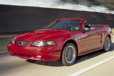 2003 Ford Mustang - Red 2003 Ford Mustang convertible in motion on a highway.