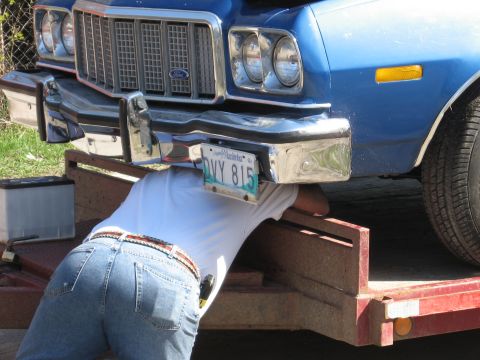 1976 Ford Ranchero - A person works on the underside of a blue vehicle, which appears to be a 1977 Ford Ranchero.