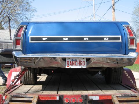 1976 Ford Ranchero - The rear of a blue 1976 Ford Ranchero is visible, loaded onto a trailer.