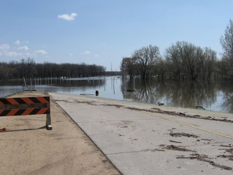 1976 Ford Ranchero - A flooded road stretches into the distance, with trees lining the banks and reflected in the calm water.