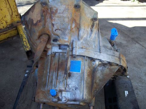1992 Ford Taurus - A heavily rusted transmission part is shown, with blue tape covering two fittings.