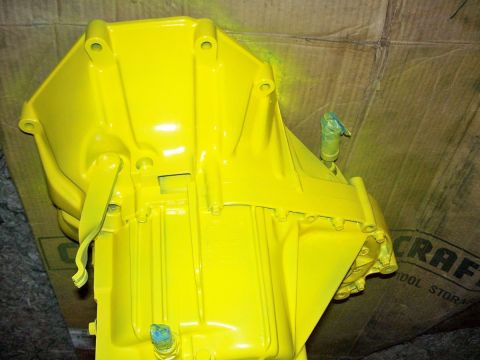 1992 Ford Taurus - A bright yellow transmission housing is shown, with blue tape covering some of the fittings.