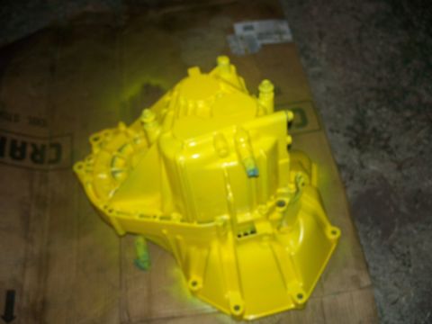 1992 Ford Taurus - A bright yellow transmission sits on a cardboard surface, likely awaiting installation or repair.