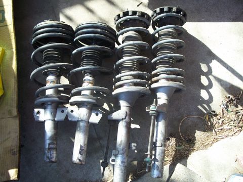 1993 Ford Taurus - These four car struts are for sale, but their specific vehicle origin is unknown.