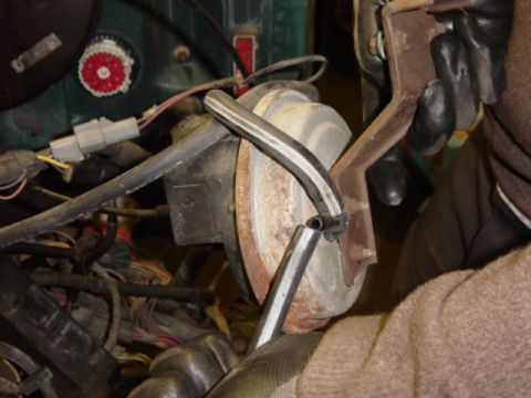 1991 Ford Bronco - Close-up view of a brake booster and vacuum line during a teardown process.