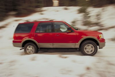 2003 Ford Expedition - Red 2003 Ford Expedition driving on a snow-covered road.