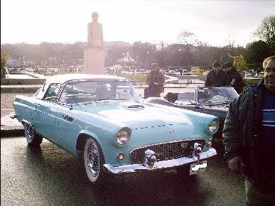 1991 Ford Crown Victoria - A classic 1955 Ford Thunderbird convertible is displayed at an outdoor event, with other vehicles and people in the background.