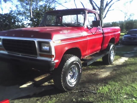 1979 Ford F-150 - This red 1979 Ford F-150 pickup truck is shown from a 3q-front angle, with another vehicle visible in the background.
