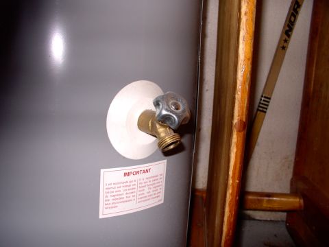 1986 Ford Bronco - Water heater drain valve with important instructions on a sticker.