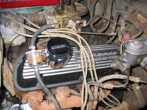 1968 Ford Bronco - The engine bay of a 1968 Ford Bronco is visible, with the V8 engine and various components.
