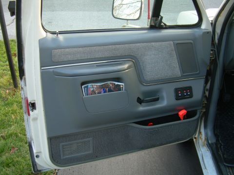 1988 Ford Bronco - Interior door panel of a Ford Bronco, the armrest, door handle, and storage pocket.