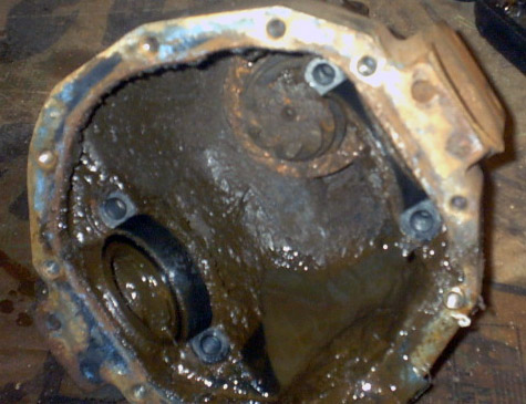 1989 Ford Bronco - Differential cover removed for rebuild, revealing internal components and old lubricant.