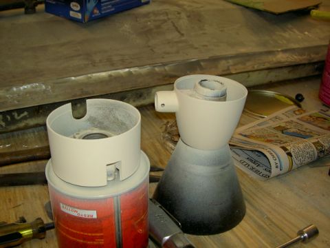1967 Ford Ranchero - Two white plastic automotive parts are shown on a workbench, with a can and newspaper nearby.