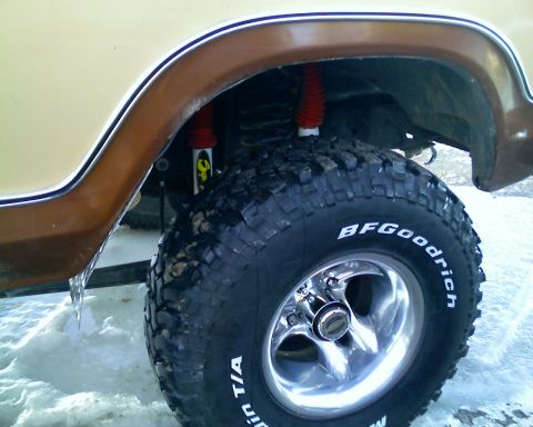1979 Ford F-150 - Close-up of the front wheel well of a two-tone tan and brown pickup, showing a BFGoodrich Mudder T/A tire on a polished three-spoke aluminu…