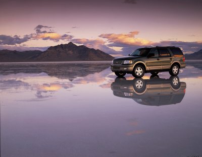 2003 Ford Expedition - A 2003 Ford Expedition is reflected in the water at sunset with mountains in the distance.