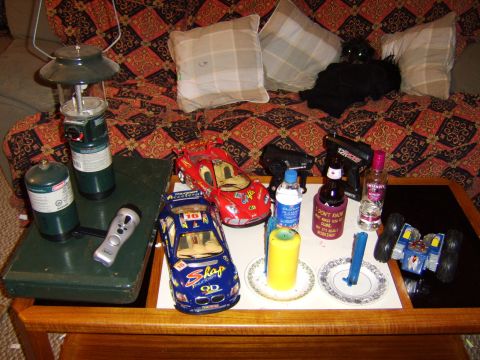 1989 Ford Bronco - A collection of toy cars, a lantern, and various bottles are arranged on a table.