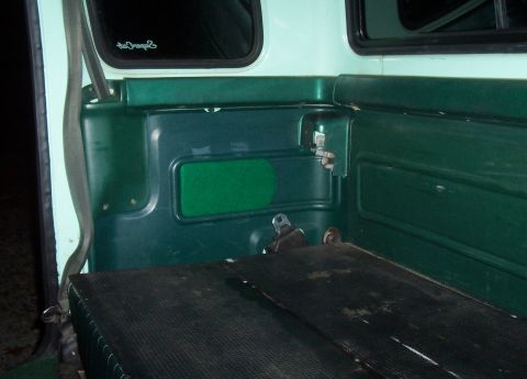 1994 Ford F-150 - Interior view of a vintage green truck, showing the door panel and floor mat.