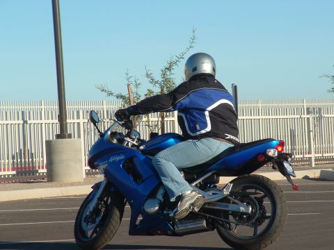 2007 Kawasaki Ninja - A blue Kawasaki Ninja motorcycle is ridden on a sunny day, with a rider in protective gear.