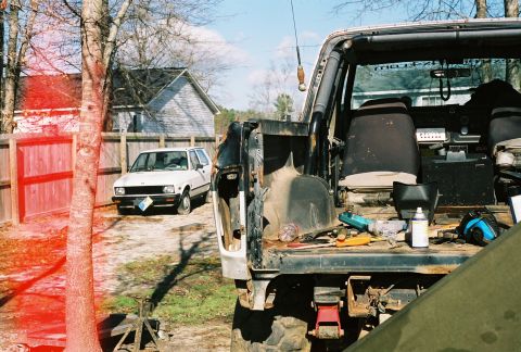 1978 Ford Bronco - Two vehicles are visible in a yard, one a black SUV and the other a white sedan.