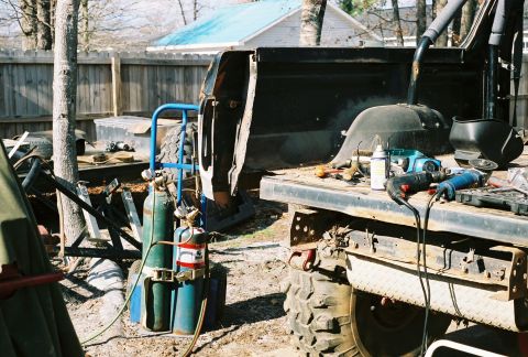 1978 Ford Bronco - Tools and welding equipment are laid out on the bed of a pickup truck, suggesting ongoing repairs or fabrication.