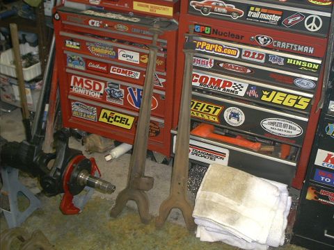1986 Ford Bronco - A collection of automotive tools and parts are organized in a garage setting.