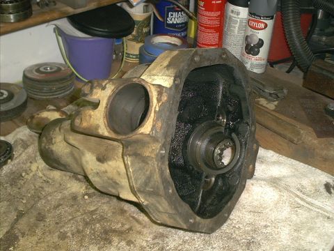 1986 Ford Bronco - A differential housing sits on a workbench, showing internal splines and a large opening.