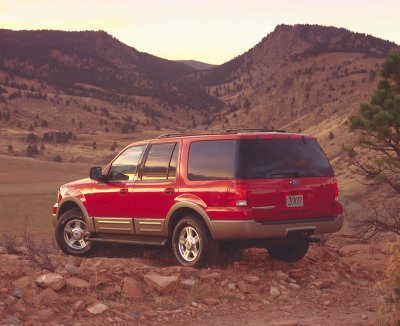2003 Ford Expedition - Rear view of a red 2003 Ford Expedition parked on a rocky hillside during sunset.