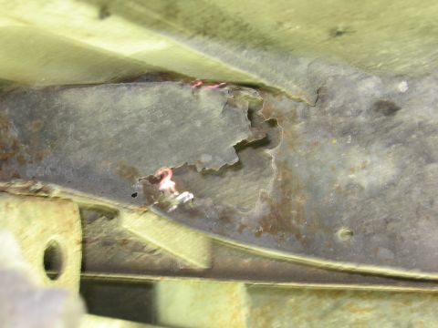 1974 Ford F-100 - The underside of a vehicle shows significant rust and damage to its metal frame.