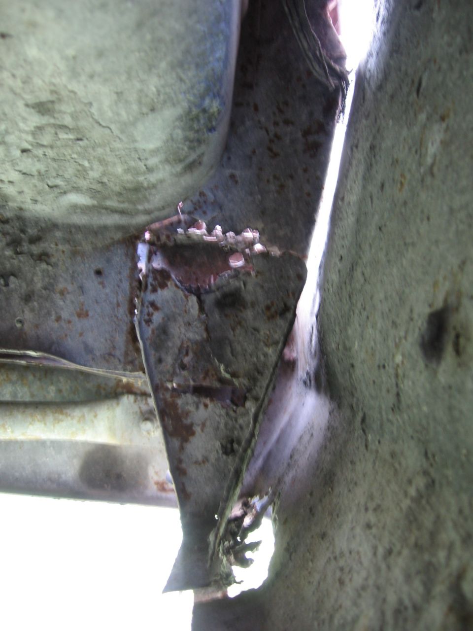 Close-up of rusted frame damage with visible SuperMotors.net watermark