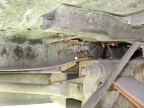 1974 Ford F-100 - The undercarriage of the vehicle shows significant rust and wear on the frame and suspension parts.