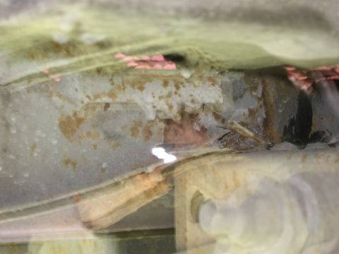 1974 Ford F-100 - Close-up view of a corroded vehicle frame, with visible damage and rust. The 'SUPERMOTORS' watermark is present in the lower right corner.