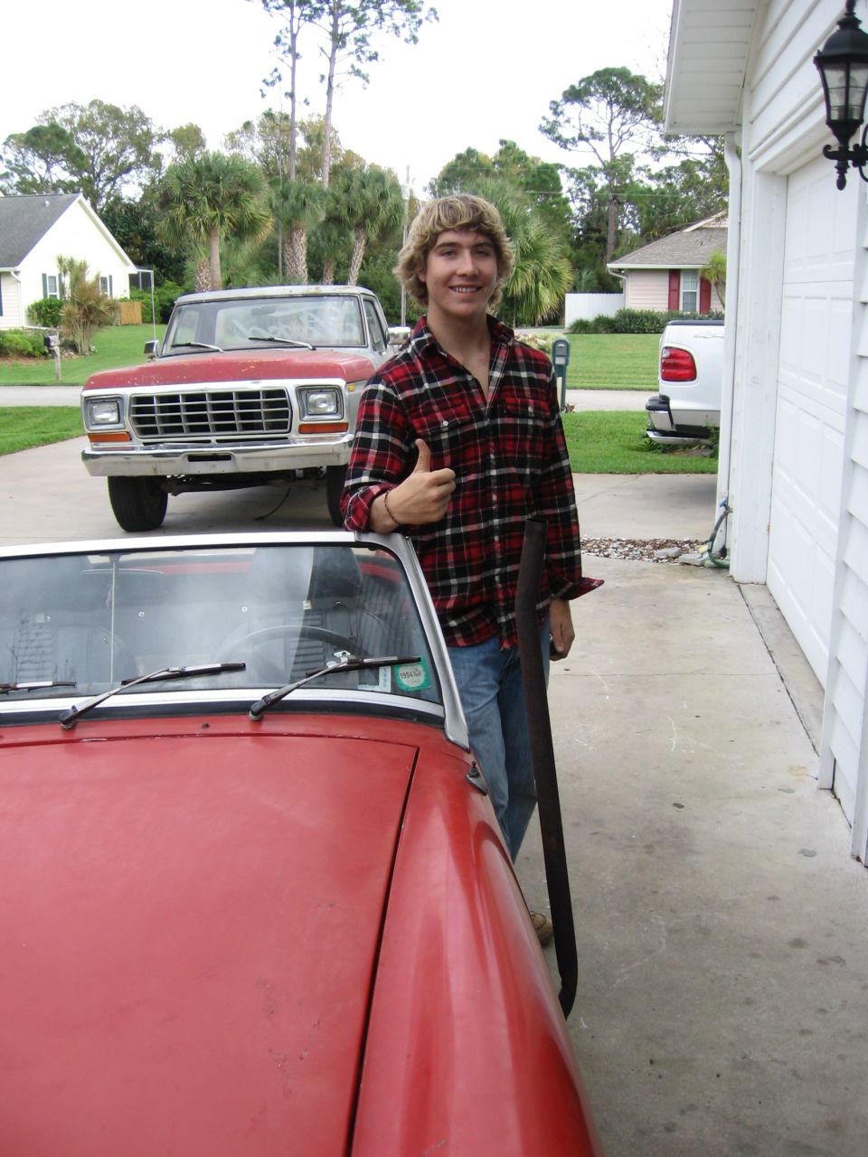 Red pickup truck with a prominent grille and quad headlights, seen from a 3/4 front angle