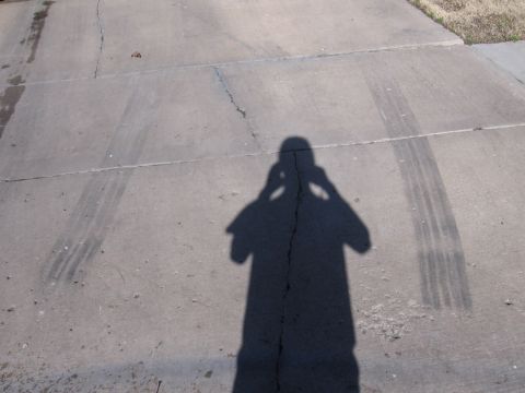 1984 Ford Bronco II - Shadow of photographer on concrete with tire tracks visible.