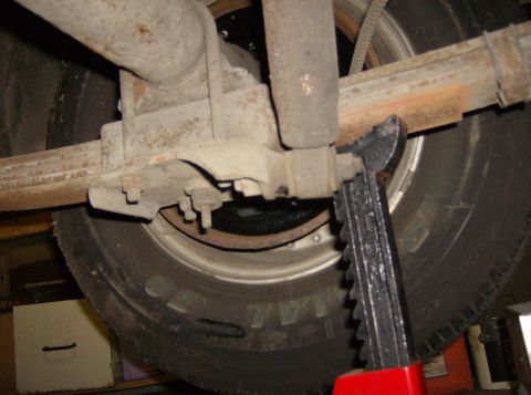 1970 Ford Ranchero - Close-up view of a vehicle's rear axle and leaf spring assembly, supported by a jack.