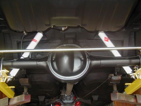 1970 Ford Mustang - Underside view of a vehicle's rear axle, differential, and suspension components, including white shock absorbers.